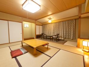 a living room with a table and a dining room at Kumanoyu Hotel in Yamanouchi