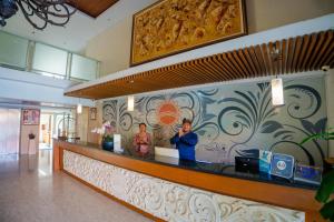 two people standing at the counter of a restaurant at The Sun Hotel & Spa Legian - CHSE Certified in Legian
