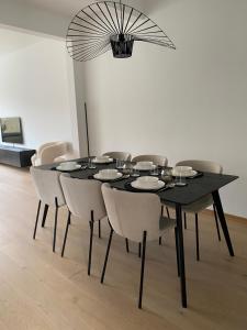 uma mesa de jantar preta com cadeiras e um lustre em Cosy Apartment near Antwerp em Mortsel