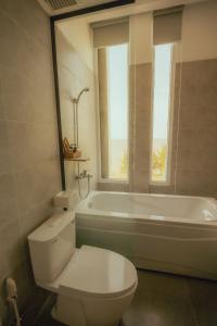 a bathroom with a toilet and a tub and a window at LÊ ĐOÀN HOTEL in Rach Gia