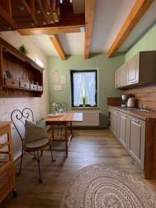 eine Küche mit einem Tisch und einem Fenster in der Unterkunft Matys Landhausperle an der Müritz in Röbel