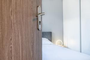 ein Schlafzimmer mit einem Bett und einer Holztür in der Unterkunft Les Anémones 6 places in Les Orres