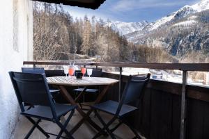 a table and chairs on a balcony with a view at Les Anémones 6 places in Les Orres