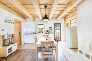 a kitchen with a wooden ceiling and a table and chairs at Drevenice Liptov - apartments under the mountains in Lazisko