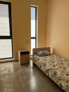een slaapkamer met een bed en 2 ramen bij Tastaq hostel in Alma-Ata