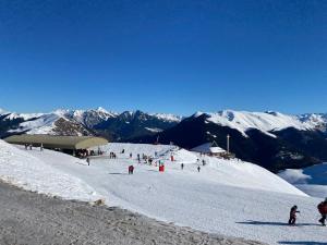 a group of people skiing down a snow covered slope at La Maison du Bonheur in Ausson