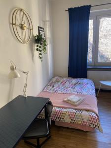 um quarto com uma cama e uma secretária com um candeeiro em Przytulny i nowoczesny apartament Małgosi, 10 min pieszo od dworca i Galerii em Katowice