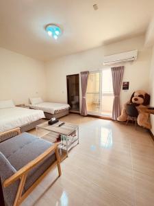 a living room with a bed and a teddy bear at Xinzhan 23 B&B in Taitung City