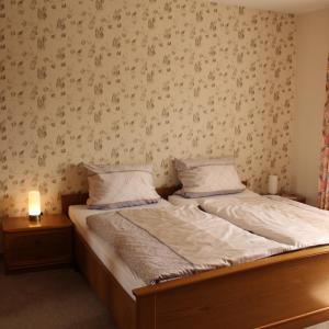 a bedroom with a bed and a wall with wallpaper at Ferienwohnung Mietzner in Laubach