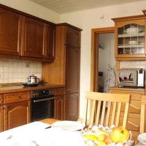 a kitchen with a bowl of fruit on a table at Ferienwohnung Mietzner in Laubach +8 photos