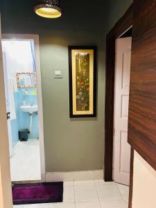 a hallway with a door to a bathroom with a sink at THE NOOK Nidana Suites in Guwahati
