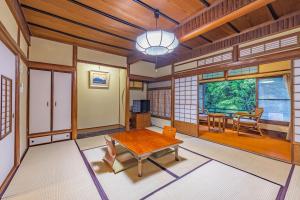 a living room with a wooden table and chairs at Ichinoyu Honkan in Hakone