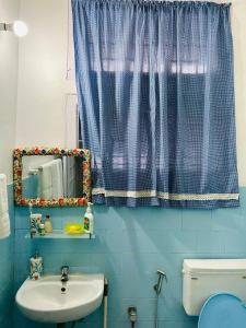 a blue bathroom with a sink and a mirror at THE NOOK Nidana Suites in Guwahati