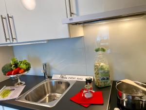 una cucina con lavandino e ciotola di verdure di Casa Sonora a Orselina