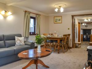 a living room with a couch and a table at Scalelands Cottage in Frizington