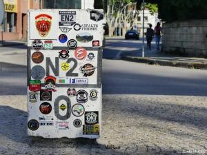 a refrigerator covered in stickers on the side of a street at Forte de São Francisco Hotel Chaves in Chaves