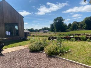 a garden in front of a wooden building at Granny’s Hut in Thornhill