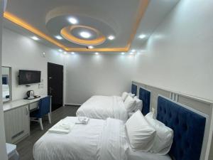 a hotel room with two beds and a desk at Treasury Terrace Apartments in Wadi Musa
