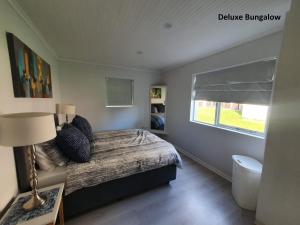 a small bedroom with a bed and a window at Milkwood Country House in Port Elizabeth +18 photos