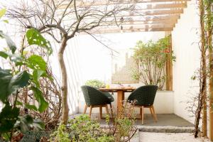 un patio al aire libre con 2 sillas y una mesa en T'Luz en Oporto