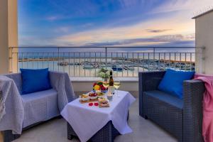 a balcony with two chairs and a table with food on it at POSTU D'INCANTU in Sciacca