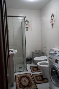 Un baño con lavadora y un inodoro. en Lovely apartment in the heart of Tirana, en Tirana