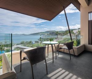 a balcony with a table and chairs and a view of the ocean at Hyatt Regency Phuket Resort - SHA Extra Plus in Kamala Beach