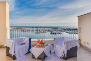 a balcony with two tables and a view of a marina at POSTU D'INCANTU in Sciacca