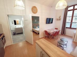 una cucina, un soggiorno con tavolo e una camera da letto di LA GABICHE - NOUVEAU T2 FACE AUX THERMES ad Aulus-les-Bains