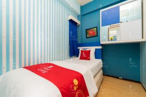 a small room with a bed with a red blanket at RedLiving Apartemen The Suites Metro - Prisma in Bandung