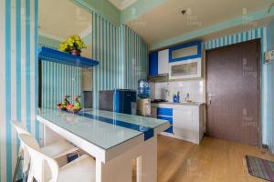 a kitchen with blue and white striped walls and a counter at RedLiving Apartemen The Suites Metro - Prisma in Bandung