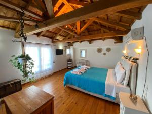 ein großes Schlafzimmer mit einem blauen Bett und Holzdecken in der Unterkunft Agnanti Villas 1 in Isómata