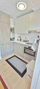 una cocina con armarios blancos y una alfombra en el suelo en Artaza Home, en Sopelana