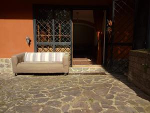 a white couch sitting in front of a door at la tana nel bosco in Durazzano