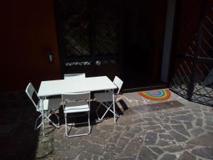 a white table and chairs on a stone floor at la tana nel bosco in Durazzano
