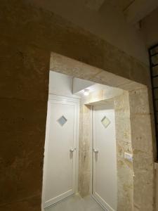 a room with a white door and a stone wall at Casa 68 Ortigia in Syracuse +25 photos