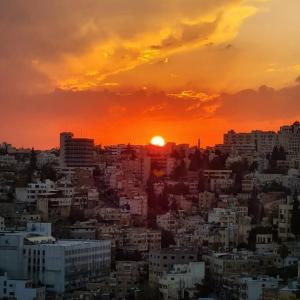 a view of a city with the sun setting at The Castle Star in Amman