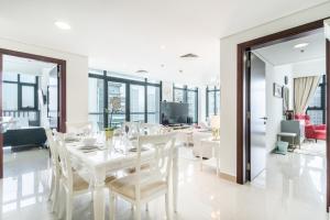 een eetkamer met een witte tafel en stoelen bij Lakeside Residence - 2BR Apartment - Allsopp&Allsopp in Dubai