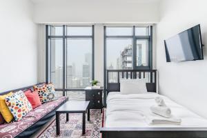een woonkamer met een bed en een bank bij Lakeside Residence - 2BR Apartment - Allsopp&Allsopp in Dubai