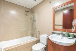 a bathroom with a sink and a toilet and a tub at Lakeside Residence - 2BR Apartment - Allsopp&Allsopp in Dubai