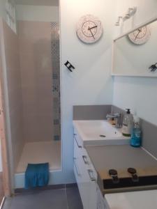 a white bathroom with a shower and a sink at maison mitoyenne avec piscine Un moment chez Diane in Grasse