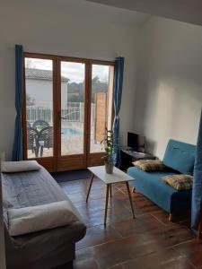 salon z kanapą i stołem w obiekcie maison mitoyenne avec piscine Un moment chez Diane w mieście Grasse