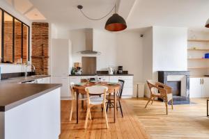 cocina y comedor con mesa de madera y sillas en Plein centre de Nantes, appartement pour 4 en Nantes