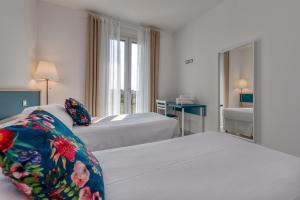 pokój hotelowy z dwoma łóżkami i lustrem w obiekcie Appartamenti Villa Campo Rosso w mieście Colà di Lazise