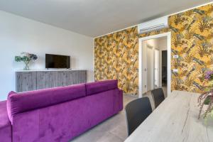 a living room with a purple couch and a table at Appartamenti Villa Campo Rosso in Colà di Lazise