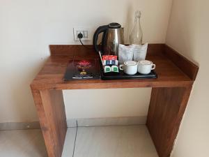 a wooden table with a coffee maker and cups on it at Hotel Divine Residency by VARSHRI in Haridwār