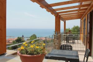 a balcony with a table and chairs and a view of the ocean at Cilento Holiday Village in Montecorice