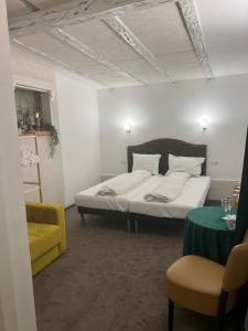 Sport Residence في باكاو: غرفة نوم بسرير وكرسي اصفر