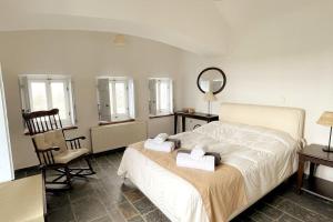 1 dormitorio con cama, silla y espejo en TΟRRE DI PIETRA-LUXURY RESIDENCE-ΑMAZING SEA VIEW en Marathón