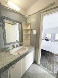ein Bad mit einem Waschbecken, einem Spiegel und einem Bett in der Unterkunft TΟRRE DI PIETRA-LUXURY RESIDENCE-ΑMAZING SEA VIEW in Marathón
